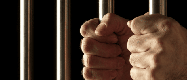 Criminal Records | close up of male hands holding jail bars