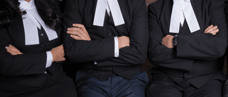 Summary Judgement | torso of three lawyers with arms akimbo